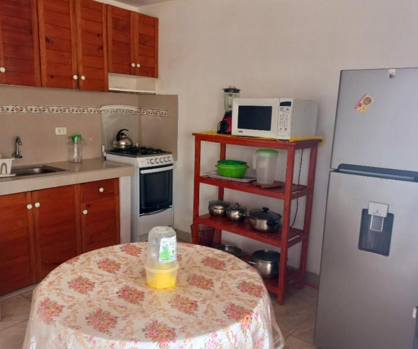 cocina con mesa y nevera blanca en Departamento de verano en Camana, en Camaná