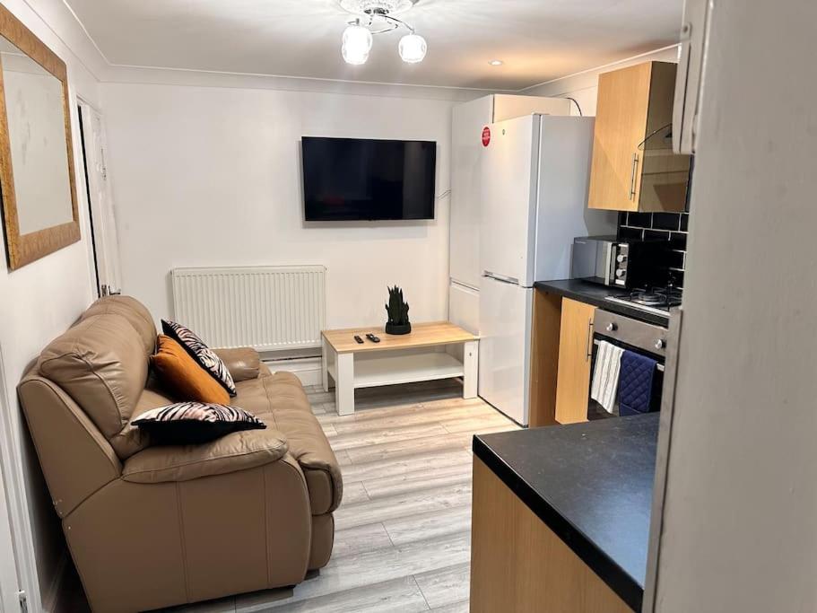 a living room with a couch and a kitchen at One small bed apartment by monishortlets in Dagenham