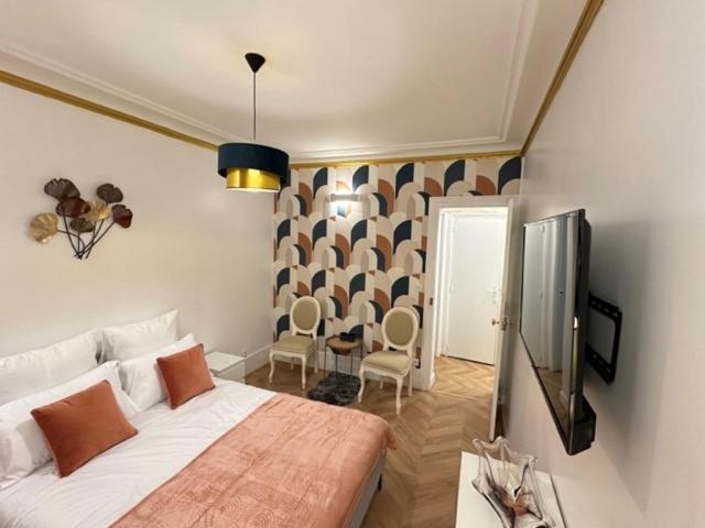 une chambre avec un lit et une télévision dans l'établissement SCI IMMO VOLTAIRE, à Paris