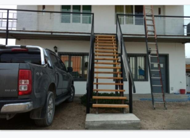 a truck parked in front of a house with a staircase at Alberto Beach in Las Grutas