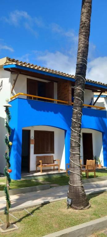 a blue and white house with a palm tree at Casa di lana in Salvador