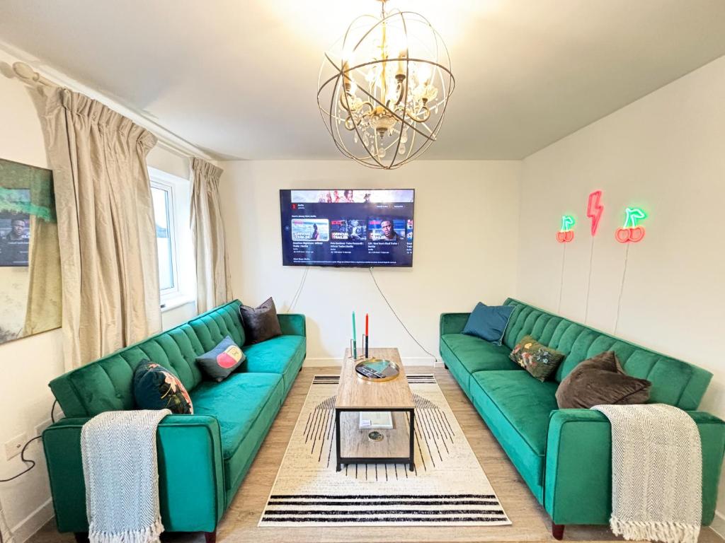 a living room with two green couches and a table at Luxury London Two Bedroom Apartment in West Dulwich