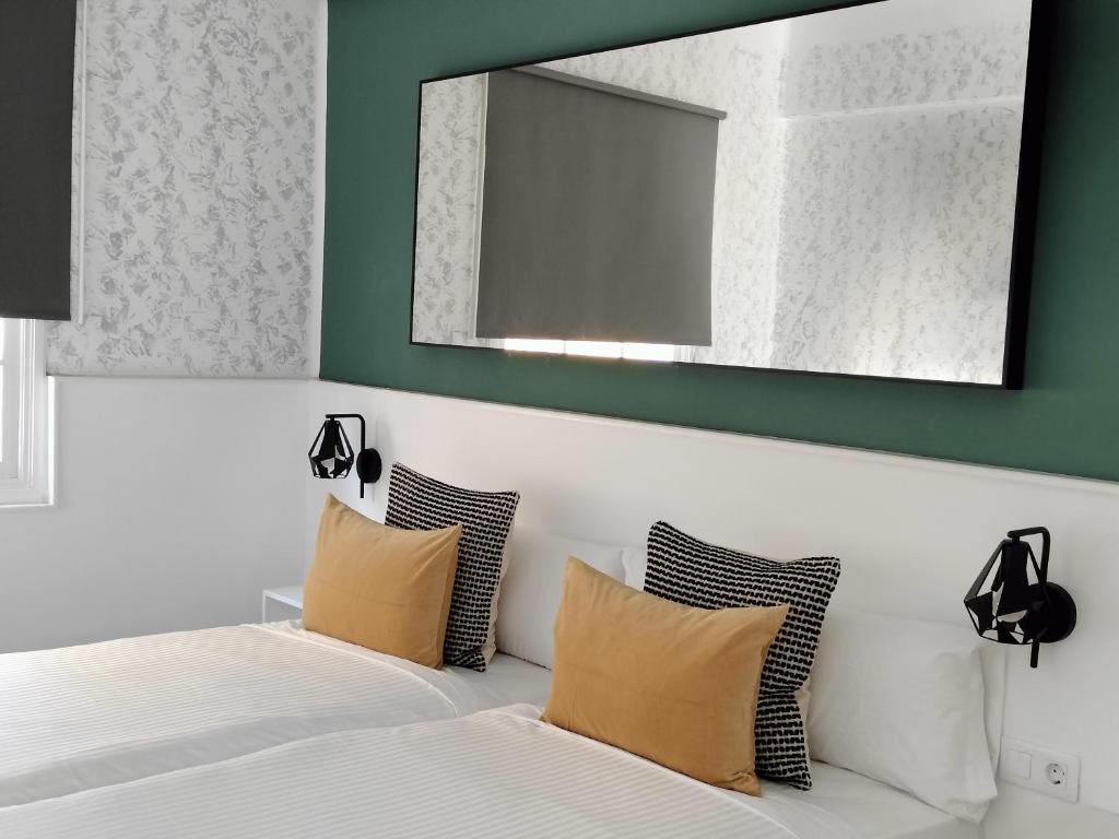 a bedroom with two beds and a mirror at Room27 in Las Lagunas