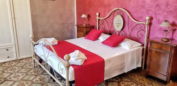 サン・ヴィート・ロ・カーポにあるCasa Vacanza Leonardaのベッドルーム1室(大型ベッド1台、赤い枕付)
