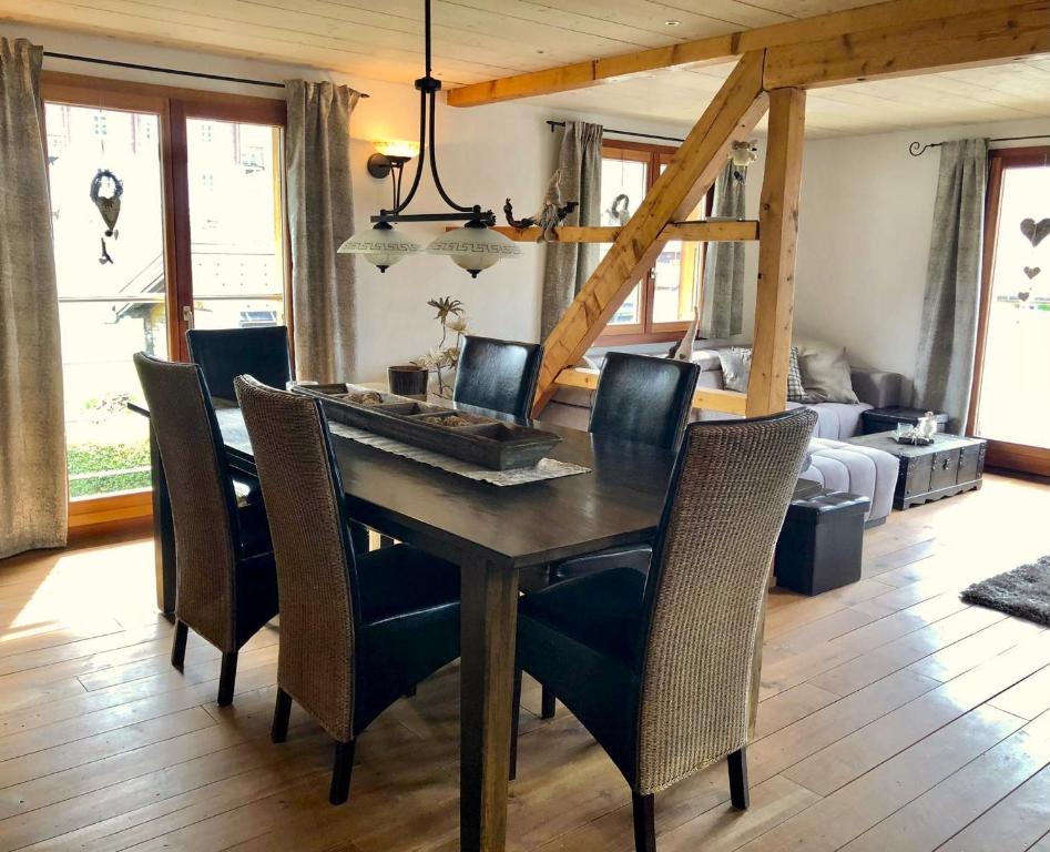 uma sala de jantar com uma mesa de madeira e cadeiras em Ferienwohnung Alpenblick Unterems em Turtmann