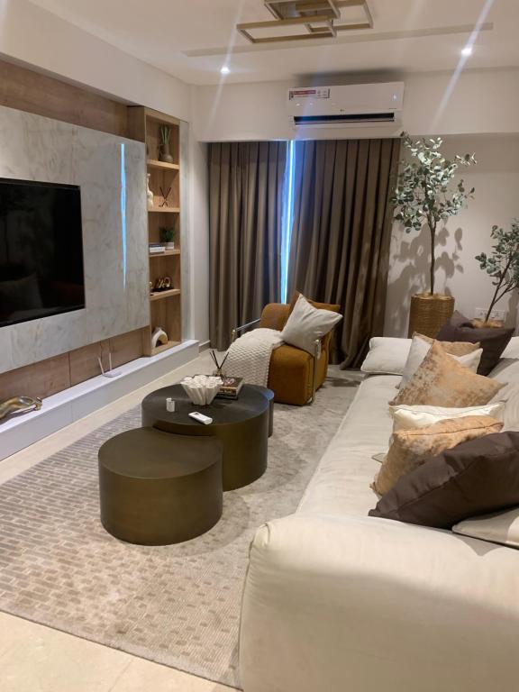 a living room with white couches and a flat screen tv at Primahem Group in Accra