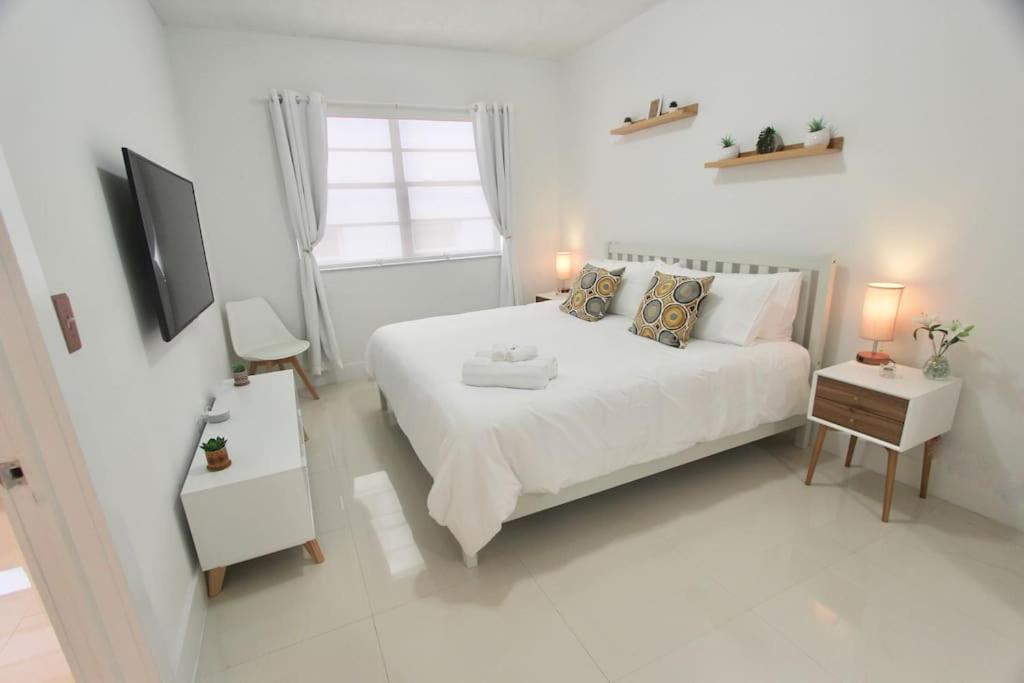 Habitación blanca con cama y ventana en Modern 1 Bd Room 1 block from the Beach, en Miami Beach