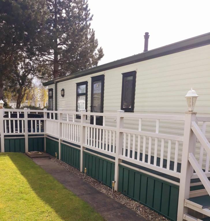 a house with a white fence and a white house at Sunrise Holidays Skegness - Emerald in Skegness