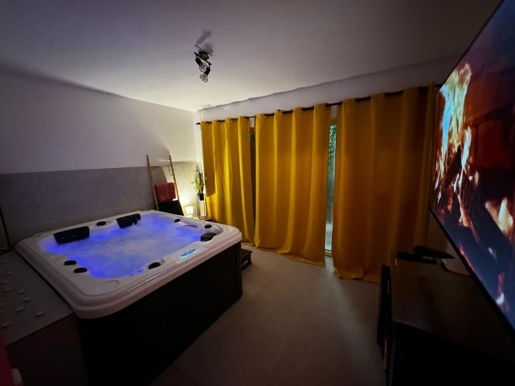 bañera grande en una habitación con cortinas amarillas en RheinMosel Glück Wellness en Koblenz