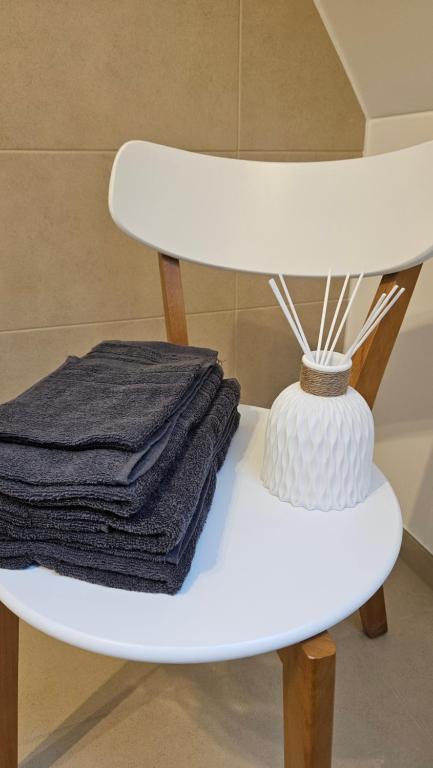 una pila de toallas en un estante blanco en un baño en FeWo AS 5 One Bamberg, en Hallstadt