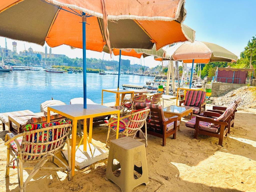 a group of tables and chairs with umbrellas on a beach at Airkela Nuba Dool2 in Aswan