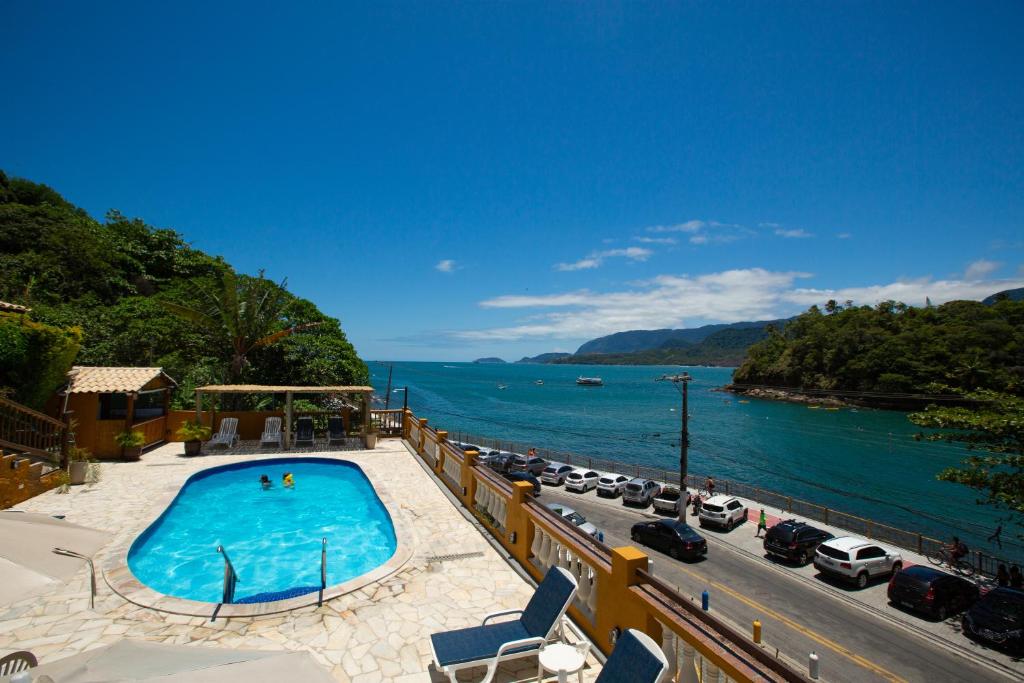 a swimming pool on a balcony with a view of the ocean at Colonial Hotel in Ilhabela