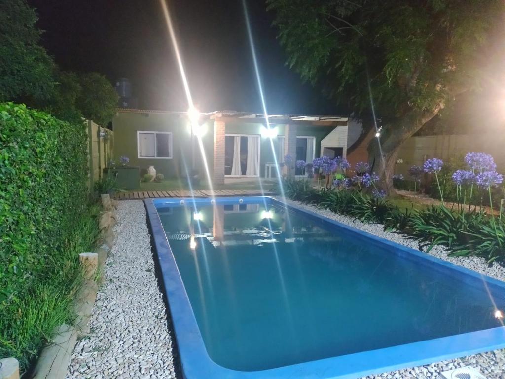 una piscina frente a una casa por la noche en Alma Mía en Lobos