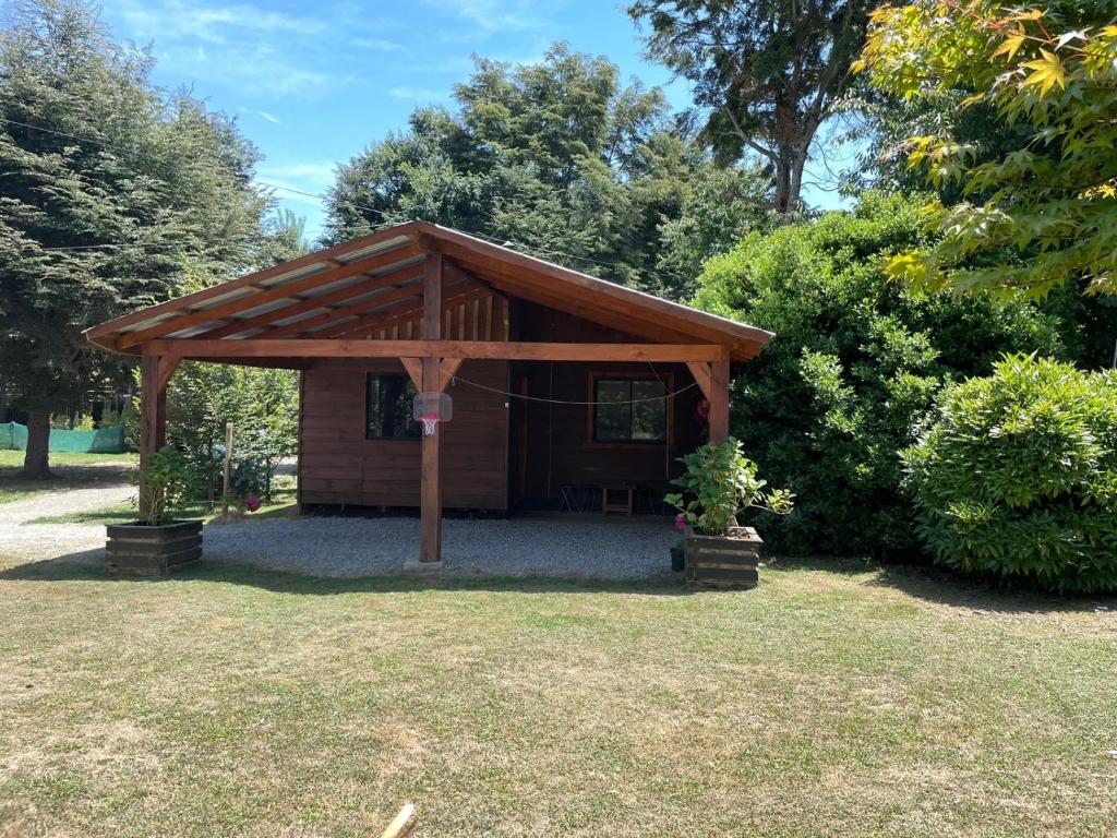 a wooden pavilion in a yard with trees at Cabañas San Agustín in Panguipulli