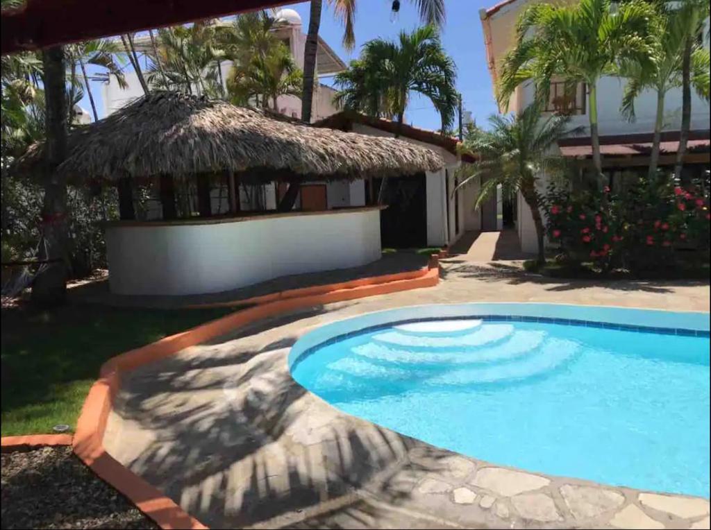 a swimming pool in front of a house at Hotel Plama Cana in Sosúa