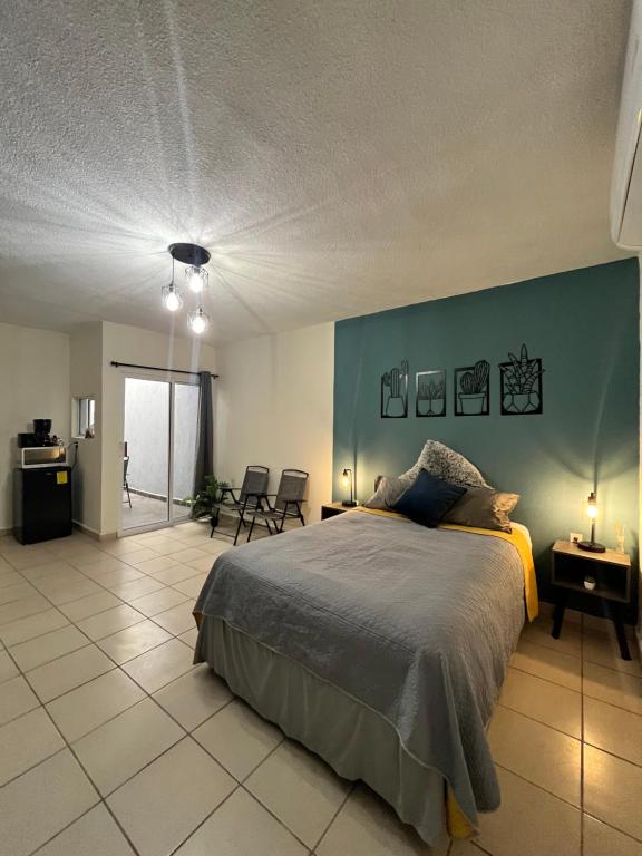 a bedroom with a bed and a blue wall at Departamentos Yahelik in Cabo San Lucas