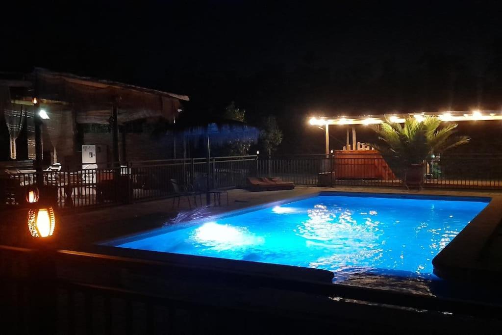 una piscina en un patio por la noche en Cabaña en Pirque