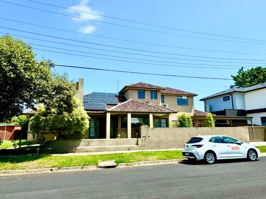 um carro branco estacionado em frente a uma casa em Four Seasons Home家四季客栈 em Melbourne