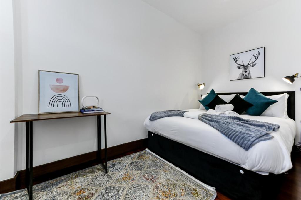 een slaapkamer met een bed met groene en witte kussens bij Vibrant 1 BD Retreat - Perfect for Couples in Hanwell