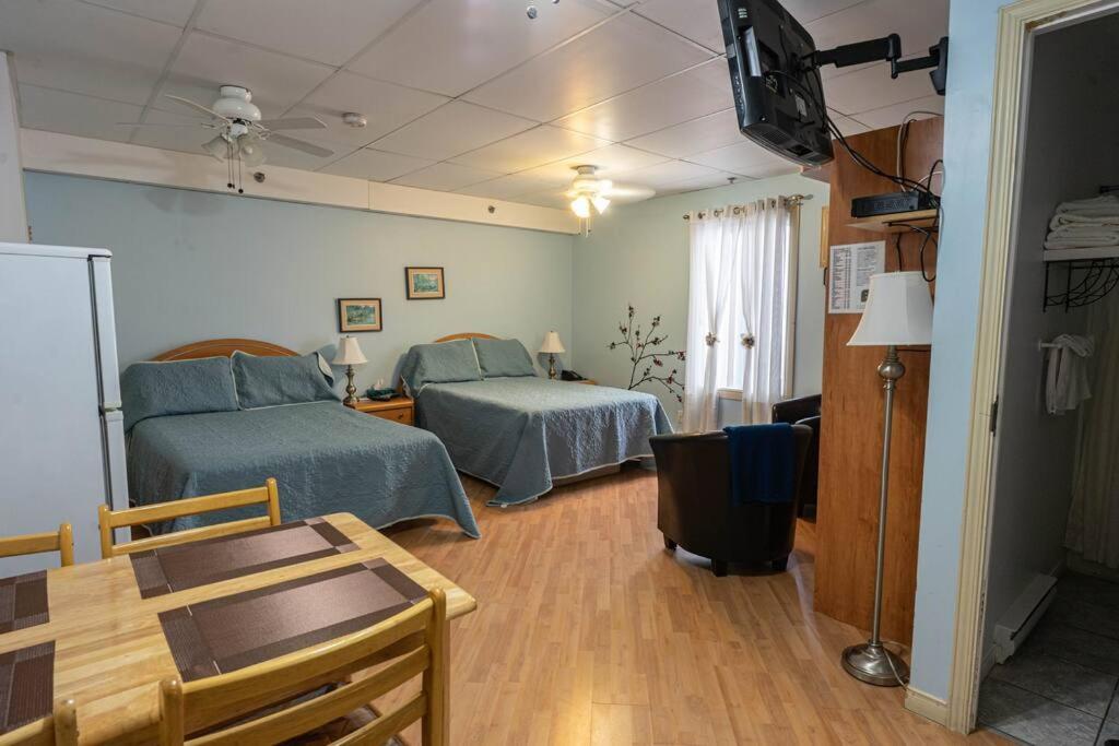 Zimmer mit 2 Betten, einem Tisch und einem TV in der Unterkunft 228 Confort et Beauté de l’Histoire en Ville  in Trois-Rivières