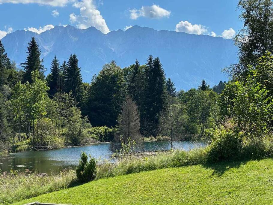 vista su un fiume con montagne sullo sfondo di Sachrang: Ferien-Wohnung am See mit Bergblick a Sachrang