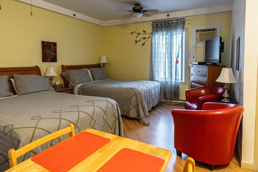 Habitación de hotel con 2 camas, mesa y sillas en 232 Espace pour l'Aventure familiale, en Trois-Rivières
