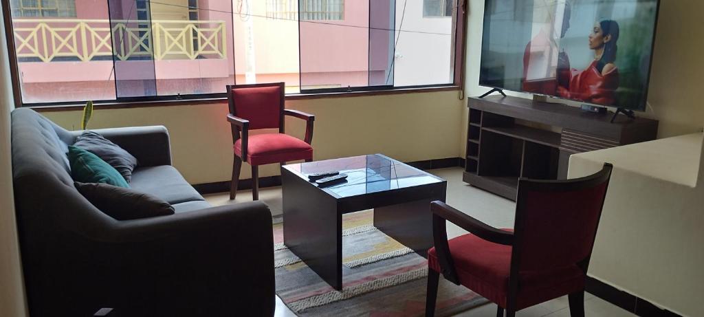 萬查科的住宿－Departamento Huanchaco，客厅配有沙发、两把椅子和一张桌子
