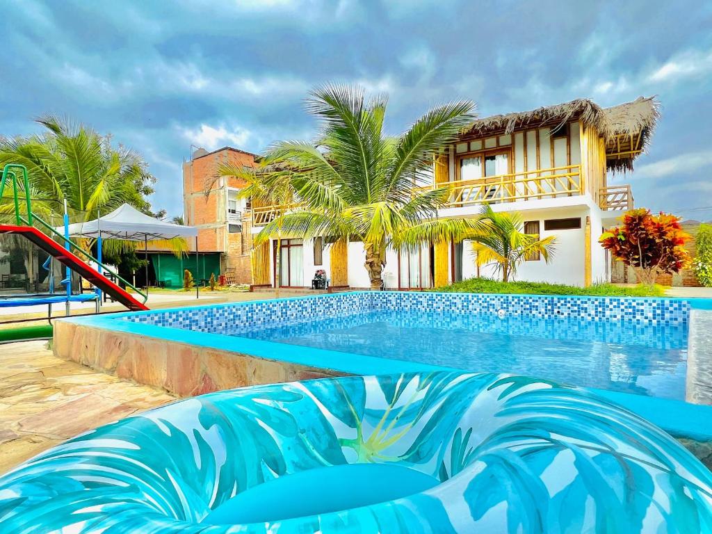 a swimming pool with a slide in front of a building at Pascana Casa Playa in Máncora