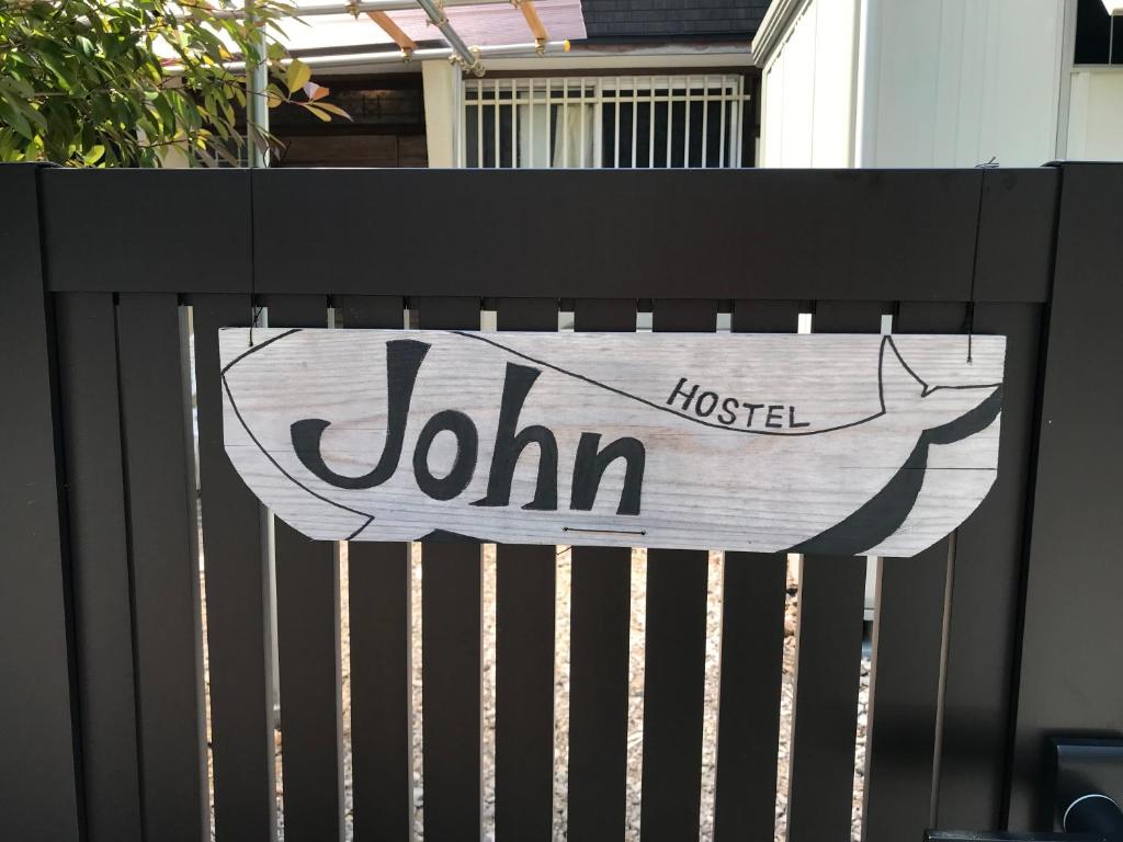 Ein Schild auf einem schwarzen Zaun mit einem Fisch drauf. in der Unterkunft Hostel John Mang ゲストハウス ジョン in Tosa