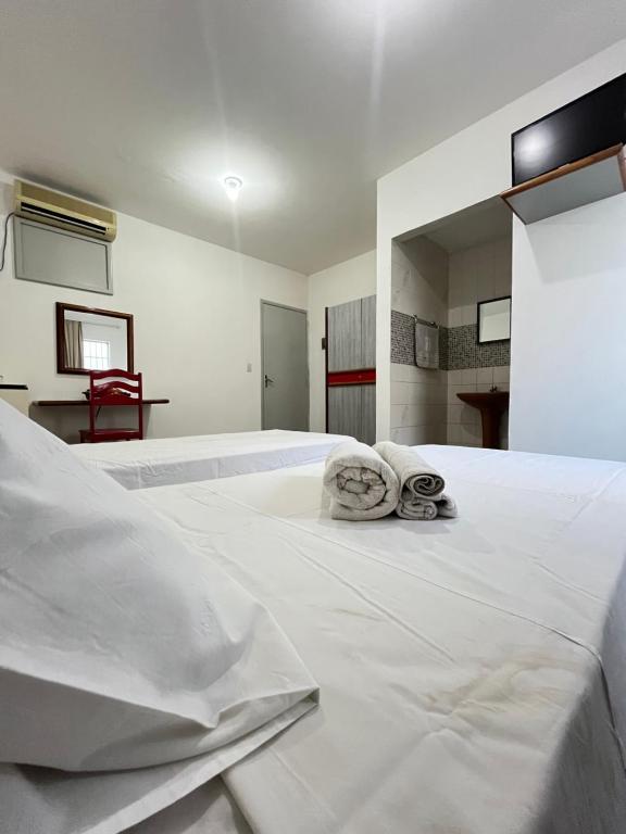 a large white bed with two towels on it at Malakoff Residence in Recife