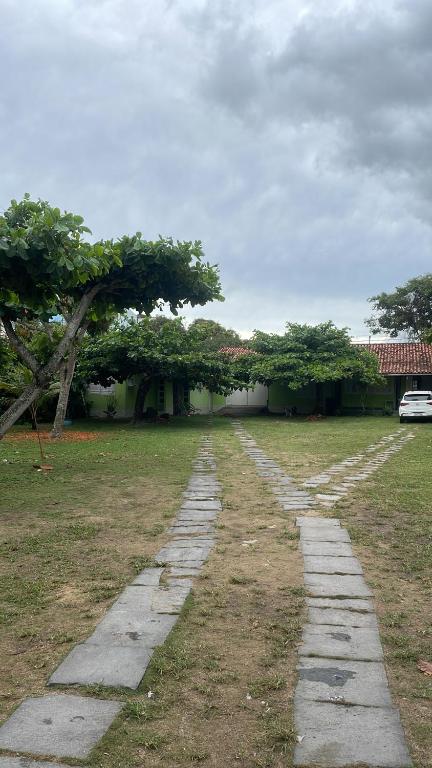 un chemin en pierre dans un champ avec un arbre dans l'établissement Paraíso tropical, à Cabo Frio