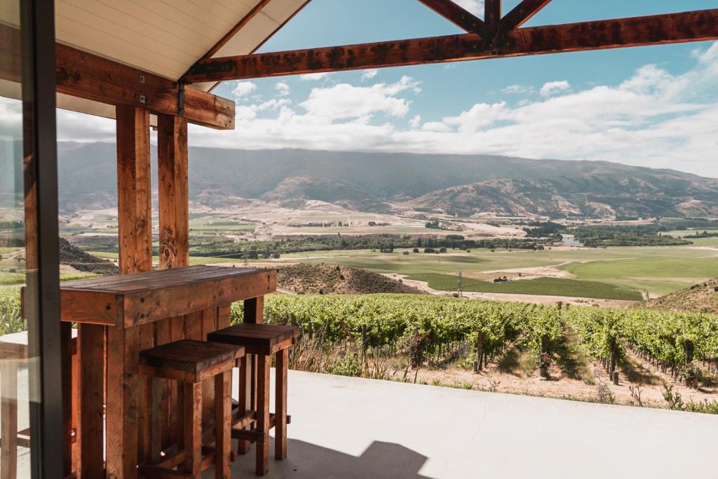 a porch with a view of a vineyard and mountains at Chinamans Ridge on Chinamans Terrace - Bendigo, Tarras - Central Otago in Tarras