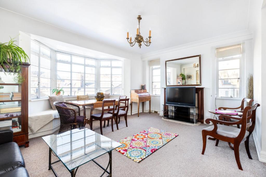 a living room with a table and chairs at Executive Knightsbridge Apartment in London