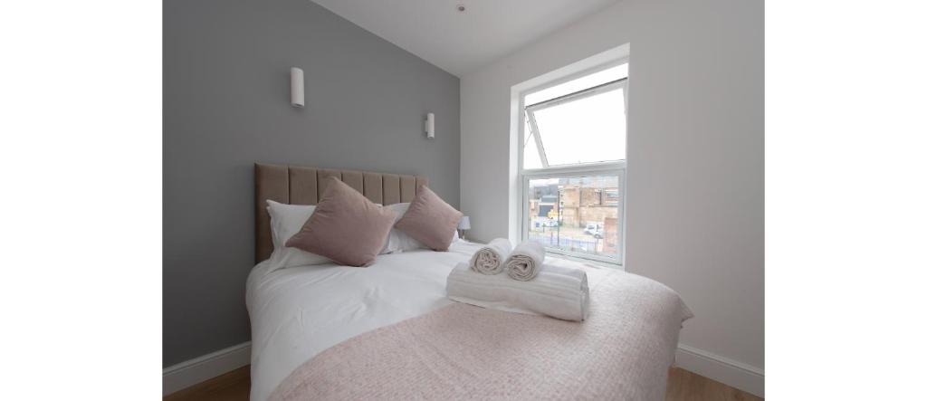 a bedroom with a bed with two towels on it at Dainty Studio Apartment Close to Everything in London