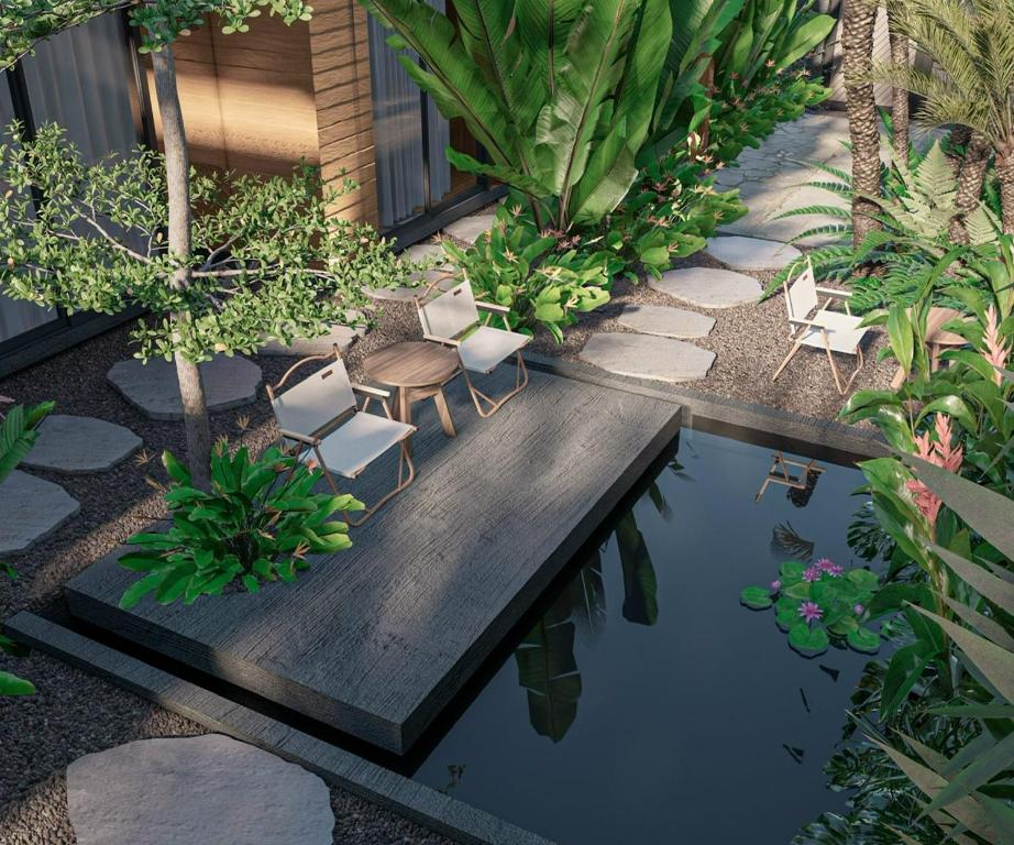 a garden with chairs and a pool of water at Kim Đồng homestay in Buôn Enao