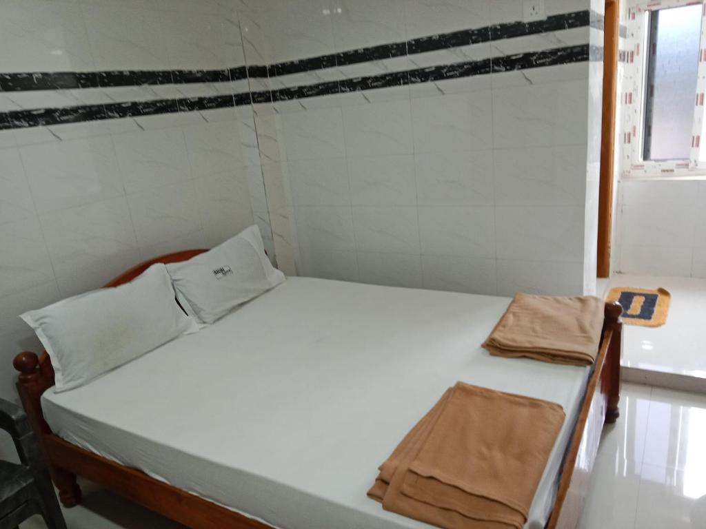 SrīsailamにあるGrand siri hotel and lodgeのベッド2台と窓が備わる小さな客室です。