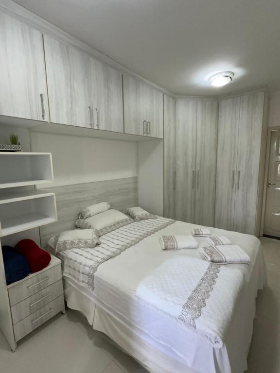 a white bedroom with two beds and cabinets at APARTAMENTO IMPERIAL IV (COMPLETO) in Castanhal