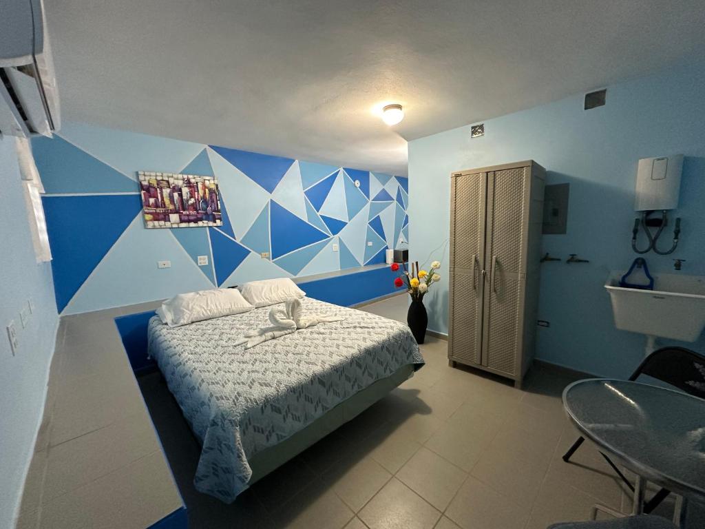 a blue and white bedroom with a bed and a table at Ocean View in Guayama