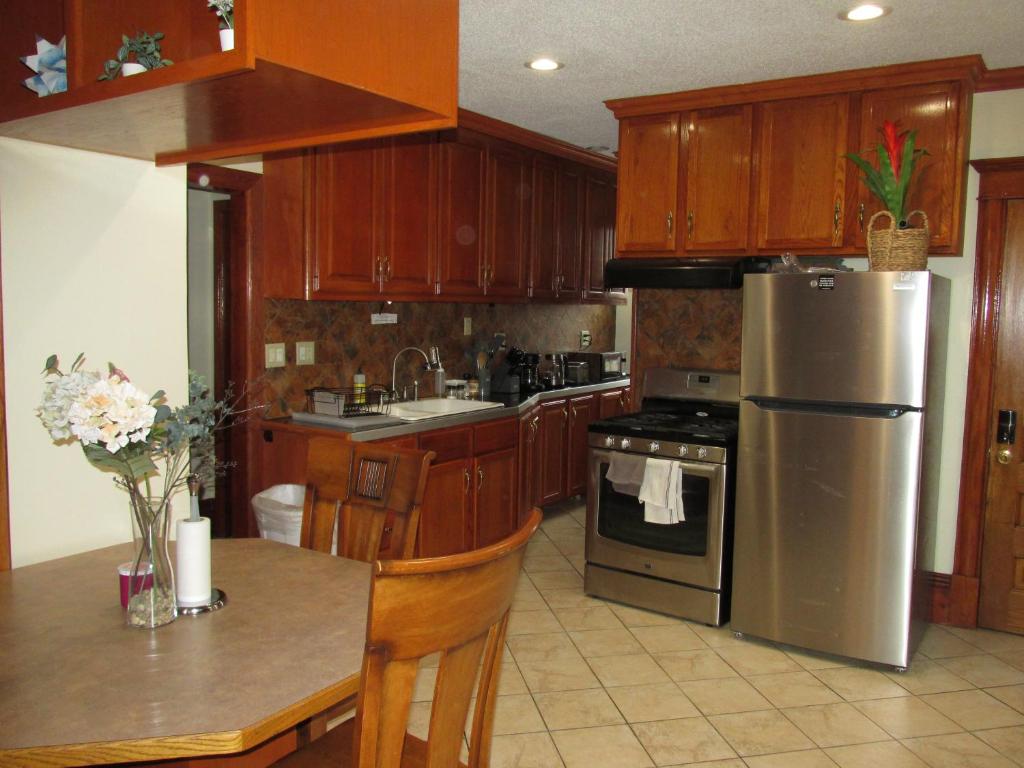 a kitchen with wooden cabinets and a stainless steel refrigerator at Victorian Home Near Downtown in Minneapolis