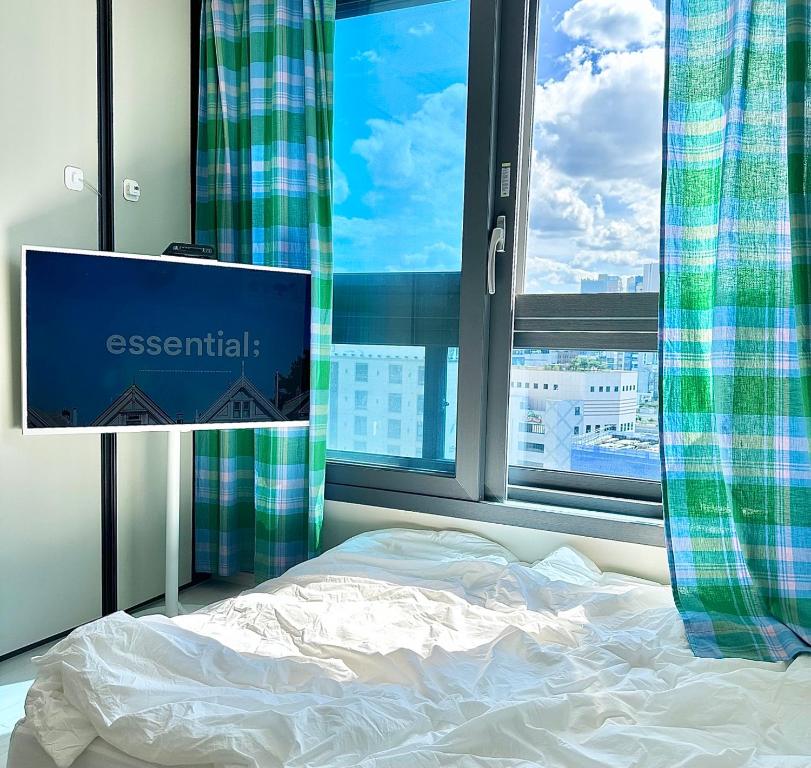 łóżko w pokoju z oknem i komputerem w obiekcie Dongseongro meomoom w mieście Daegu