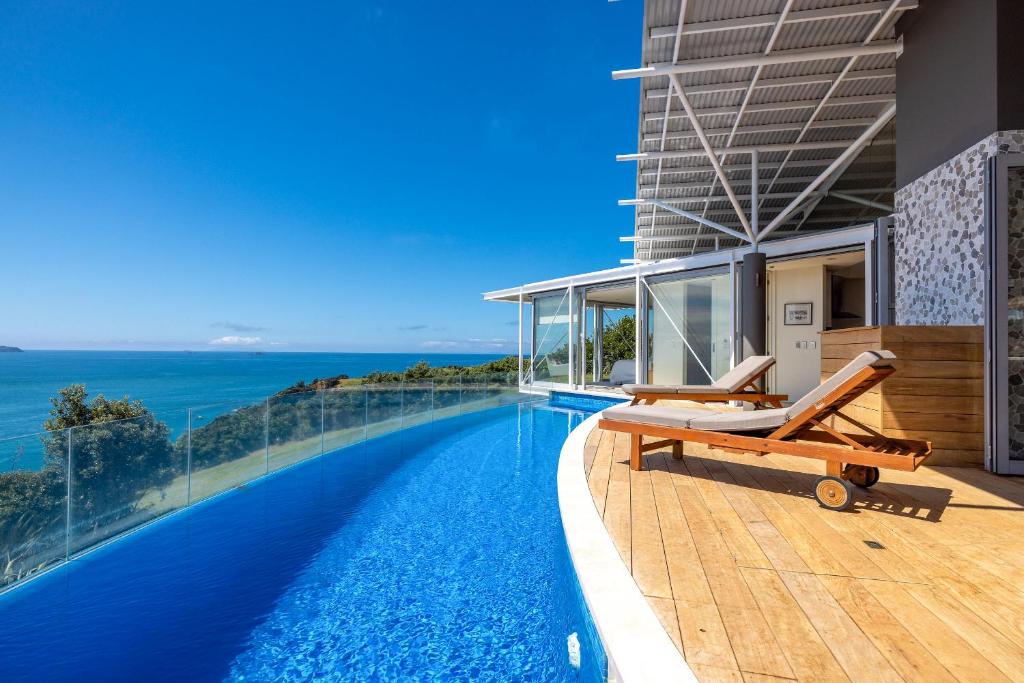 una piscina con vistas al océano en un edificio en Nikau Estate, Oneroa - Be My Guest, en Matiatia Bay