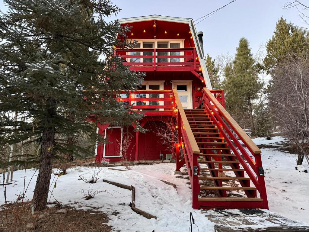 una casa roja con una escalera roja en la nieve en Maison Solange-Red Barn Farmhouse Style- Moonridge en Big Bear Lake