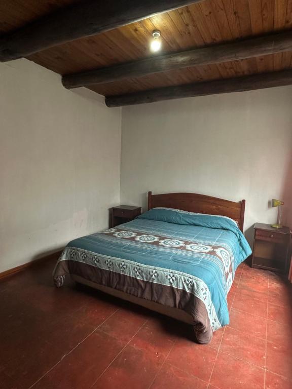 1 dormitorio con 1 cama con edredón azul en Cabaña 1, en Duao