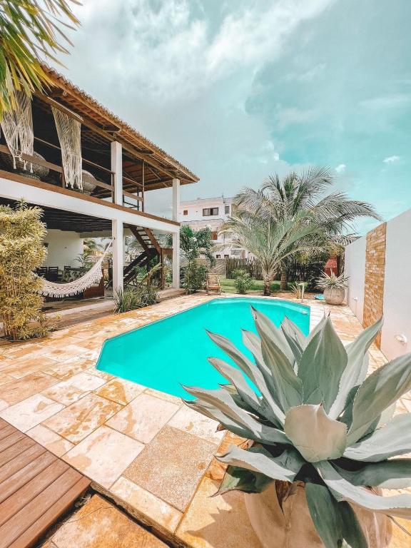 una piscina en el patio trasero de una casa con una planta en Villa Fortal Preá en Prea