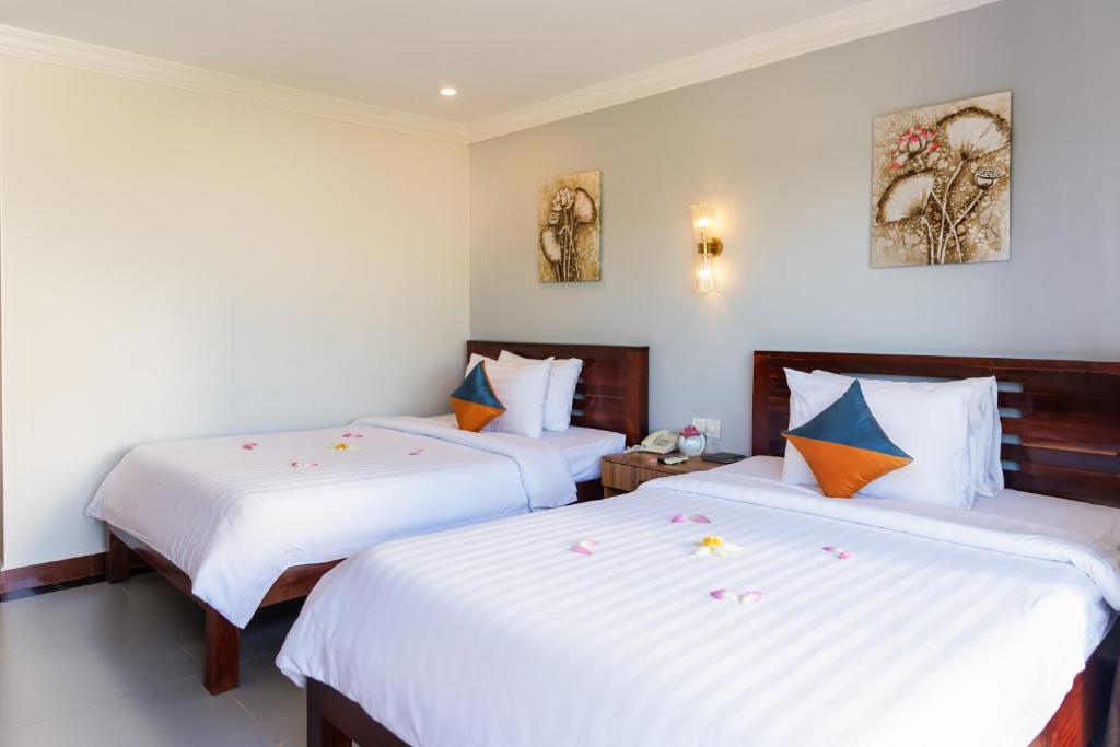 Postel nebo postele na pokoji v ubytování Ratana Angkor Hotel