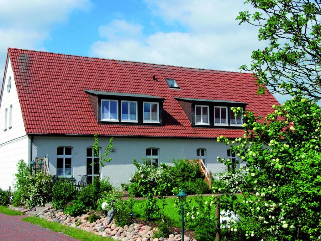 a white house with a red roof at Reihenhaus mit WLAN in Buchholz am Müritzsee in Buchholz