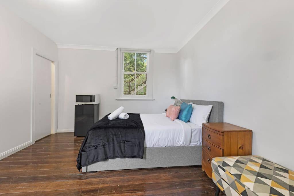 a white bedroom with a bed and a window at Budget 1 bed Private Studio close to Ashfield Station in Sydney