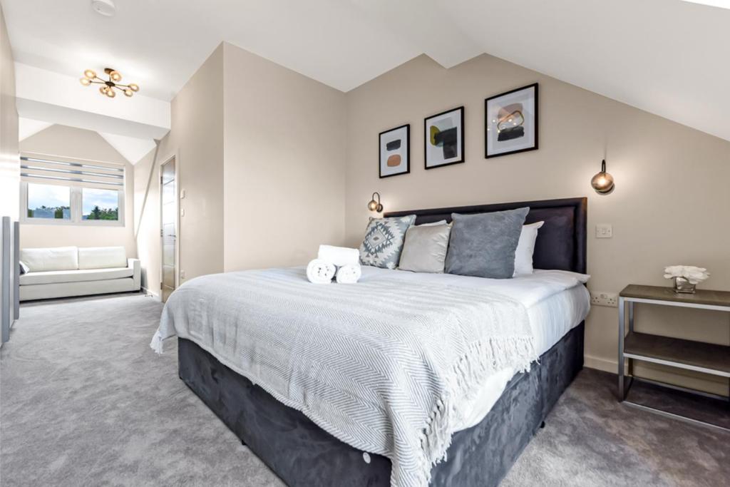 Un dormitorio con una cama grande y una ventana en Chic Retreat Residences: 3 BD Haven - Sleeps 10 en Londres