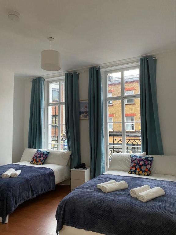 a bedroom with two beds and a window at Private Bedrooms in Camden Town, Central London (10) in London