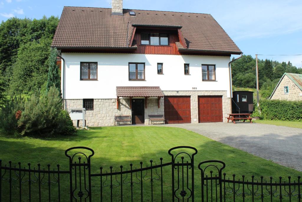 a house with a fence in front of a yard at Penzion Mühl in Bedřichov